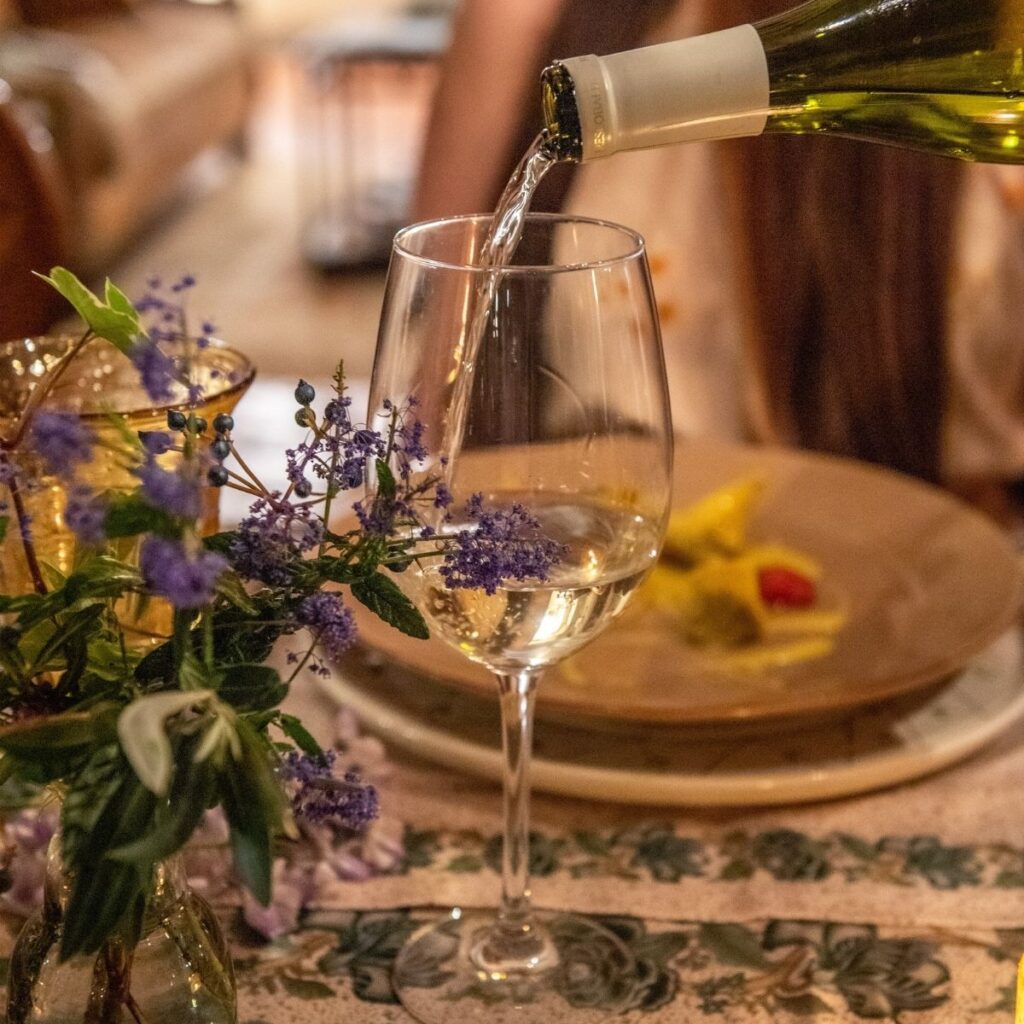 white wine being poured at fine dinner in tuscany