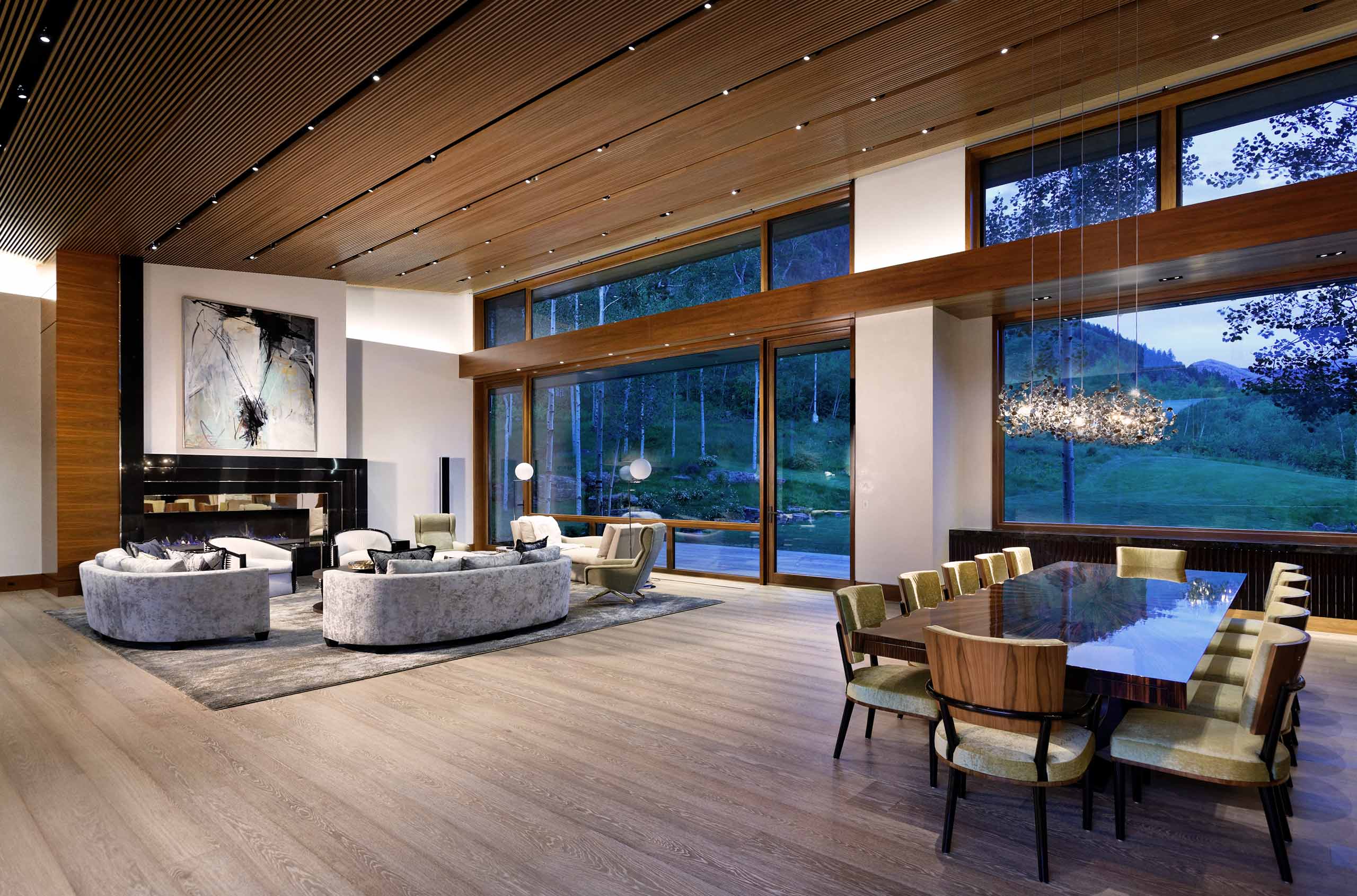 Spacious living area of an Aspen Cuvée luxury villa with oversized glass windows, sweeping mountain views and custom luxury interior design.