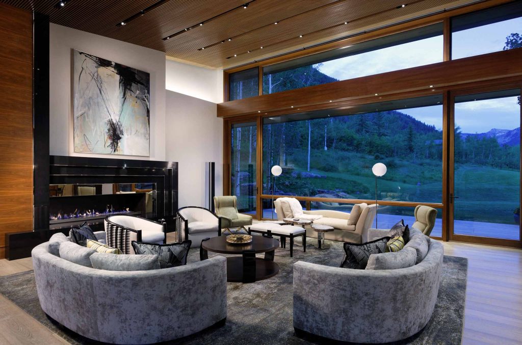 Spacious living area inside an Aspen Cuvée luxury villa with oversized glass windows, sweeping mountain views and custom luxury interior design.