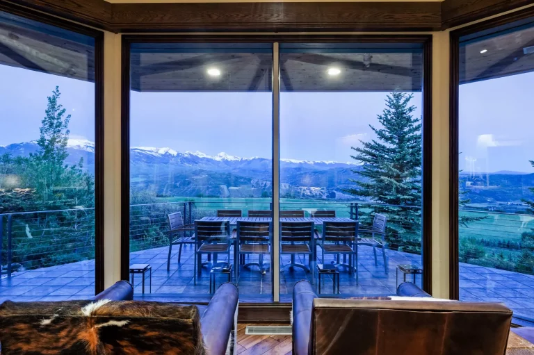View of a mountain landscape from a luxury villa with a spacious outdoor dining area.