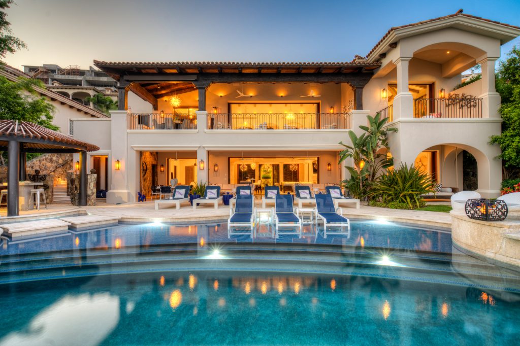 Luxury villa with pool and sun loungers in Los Cabos, Mexico, featuring a two-story design and balconies.