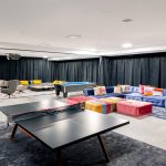 Spacious game room with ping pong table, pool table, and colorful seating area at a luxury villa.