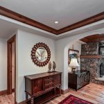 Luxury villa interior with wooden accents, stone fireplace, and mountain view in Beaver Creek, Colorado.