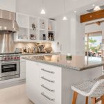 Luxury villa kitchen with modern appliances and elegant decor, featuring a large island with bar stools.