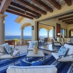 Luxurious beachfront villa with an ocean view, featuring elegant outdoor seating and interior decor in Los Cabos, Mexico.