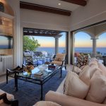 Luxury villa living room with ocean view, elegant furnishings, and open terrace in Los Cabos, Mexico.