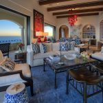 Elegant living room in a luxury villa with ocean view, featuring stylish furniture and vibrant decor.