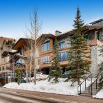 Luxury villa surrounded by snow-covered trees, located in the mountains of Vail, Colorado.