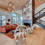 Luxury villa interior with modern furnishings, featuring a fireplace, large windows with mountain views, and elegant lighting.