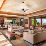 Luxurious open-plan living area with beige sofas, dining area, and ocean view in a Hawaiian villa.