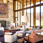 Luxurious villa living room with large windows, modern furnishings, and eclectic decor.