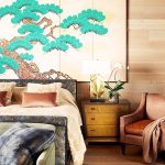 Luxurious bedroom interior with a king-sized bed, decorative wall art, elegant side table with lamp, and an upholstered armchair in a villa rental.
