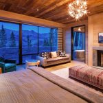 Luxurious villa interior with fireplace, large windows offering a mountain view, and stylish furnishings.