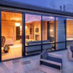 Luxurious villa interior with large glass windows, modern furniture, and warm lighting, located in Telluride, Colorado.