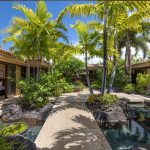 Luxury villa with tropical garden and water feature in Hawaii.