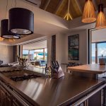 Interior view of a luxury villa kitchen and living area with ocean views in St. Barts.