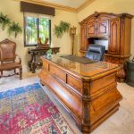 Luxury office space in a villa with wooden furniture and decorative plants.